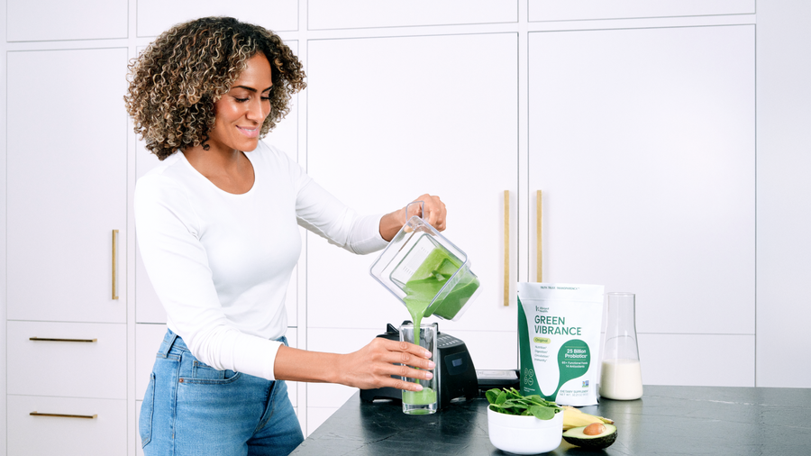 A women preparing Green Vibrance smoothie in kitchen.