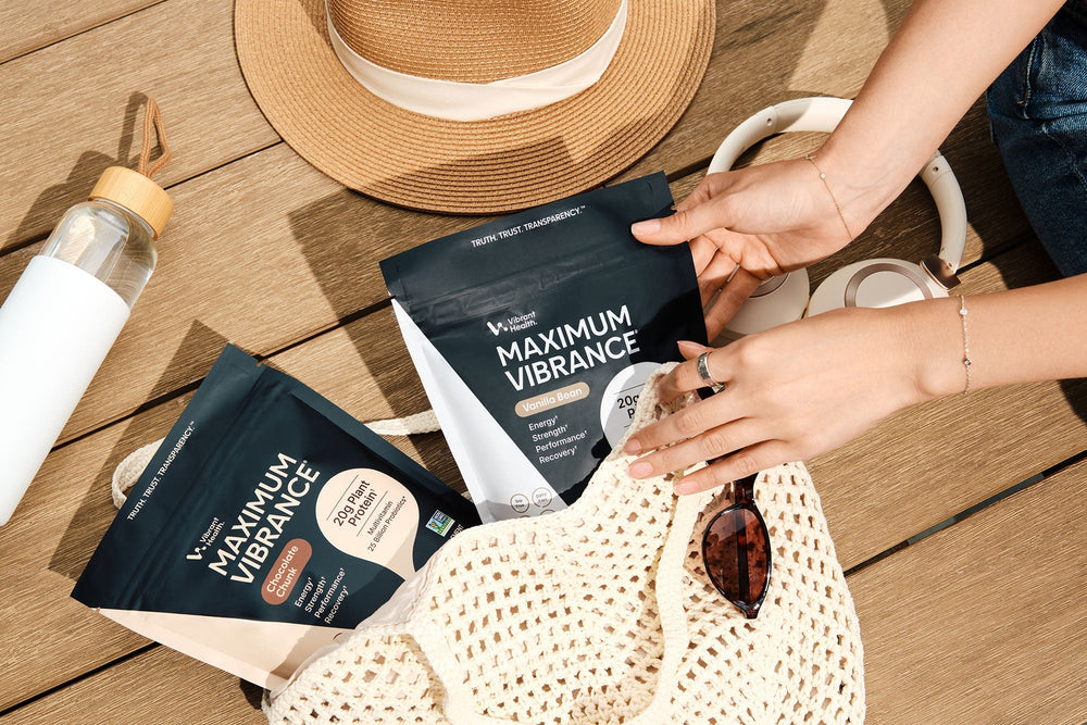 Two flavors of Maximum Vibrance pouches in a bag on a wooden table.