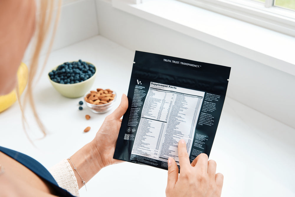 A women reading a full disclosure label on Maximum Vibrance, a greens powder, by Vibrant Health.