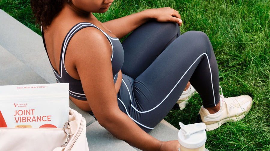 A young  female in a sports outfit and a Joint Vibrance shake in hand.